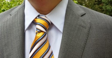 желтый галстук в полоску сочетается с костюмом
